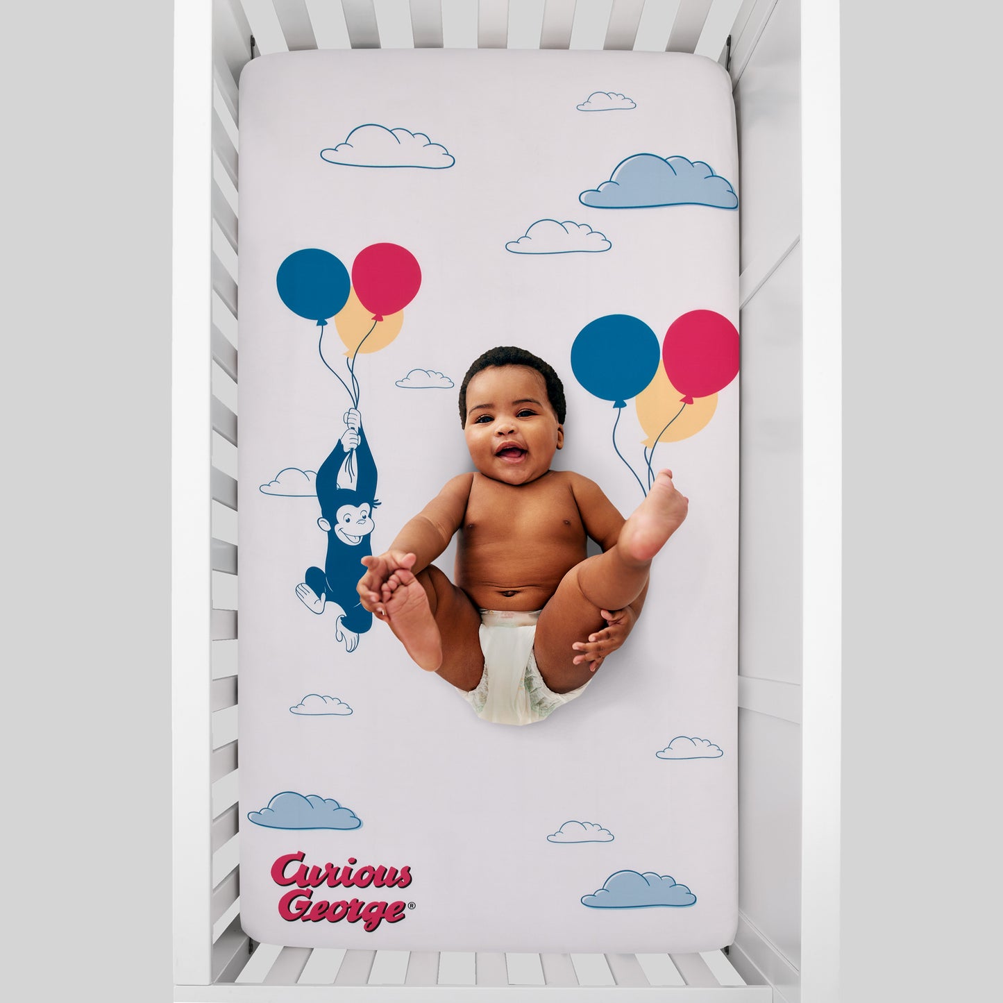 Welcome to the Universe Baby Curious George Blue, White, Red, Yellow and Green Up In The Clouds with Balloons Photo-Op Nursery Fitted Crib Sheet